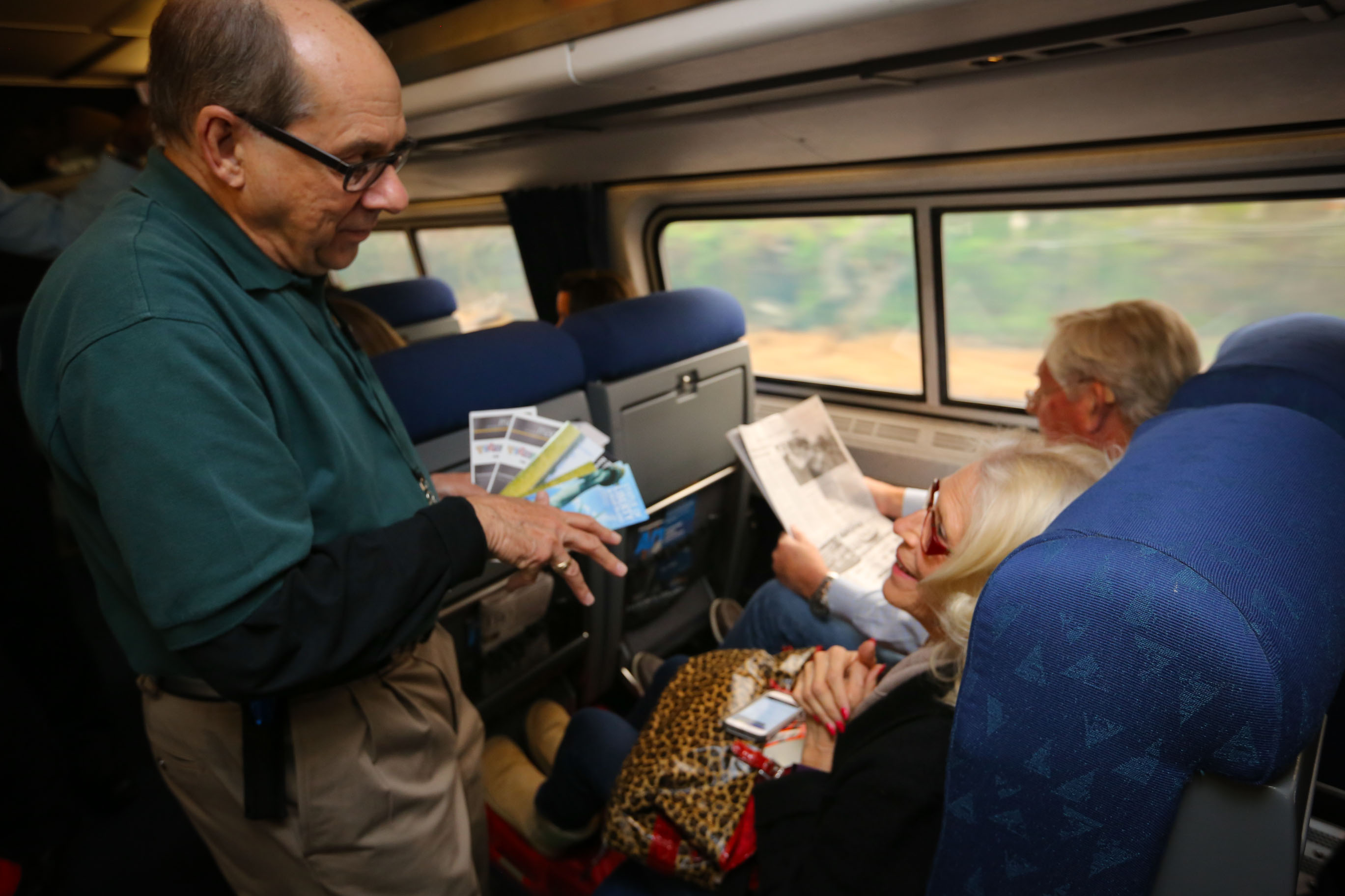 A volunteer talking with train passengers