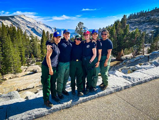 Six members of the all-women conservation corps fire crew at Yosemite National Park pose for a photo at a park viewpoint. (Photo by NPS.)