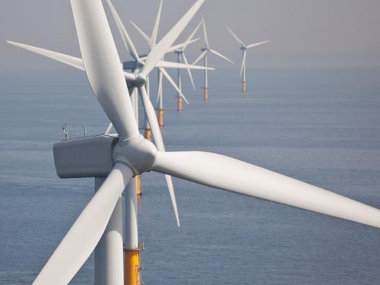 Offshore wind farm, wind turbines in ocean. 
