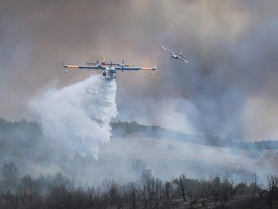 A water bomber drops water on a fire. Photo by Mike McMillan, BLM.