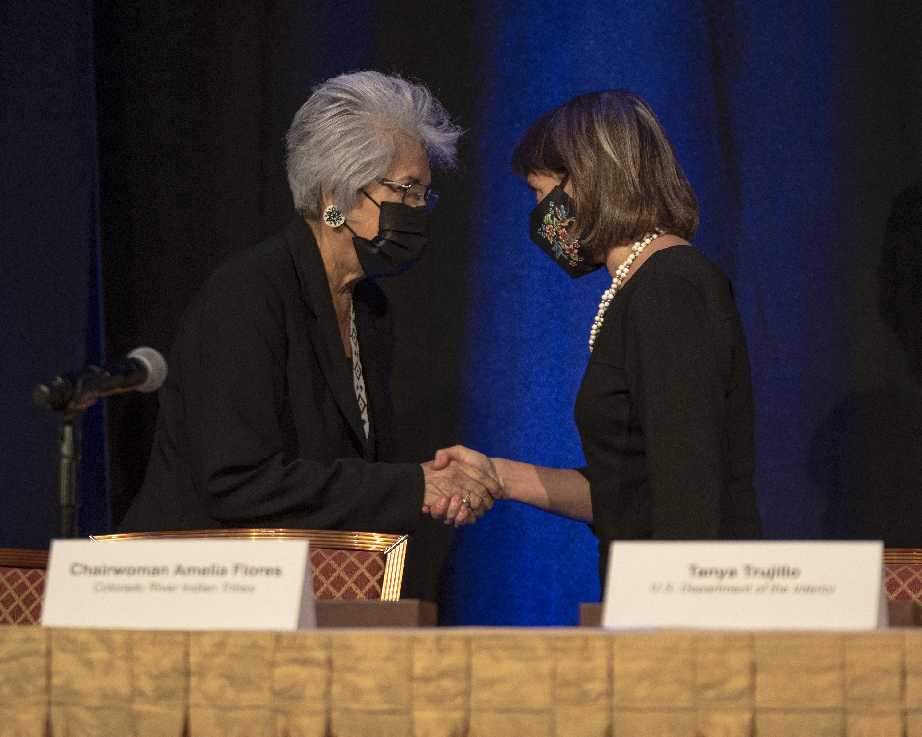 Chairwoman Flores shakes Assistant Secretary Trujillo's hand.