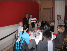 Nik-presents-photograph-with-OIA-staff-autographs-for-Doug-Domenech.gif