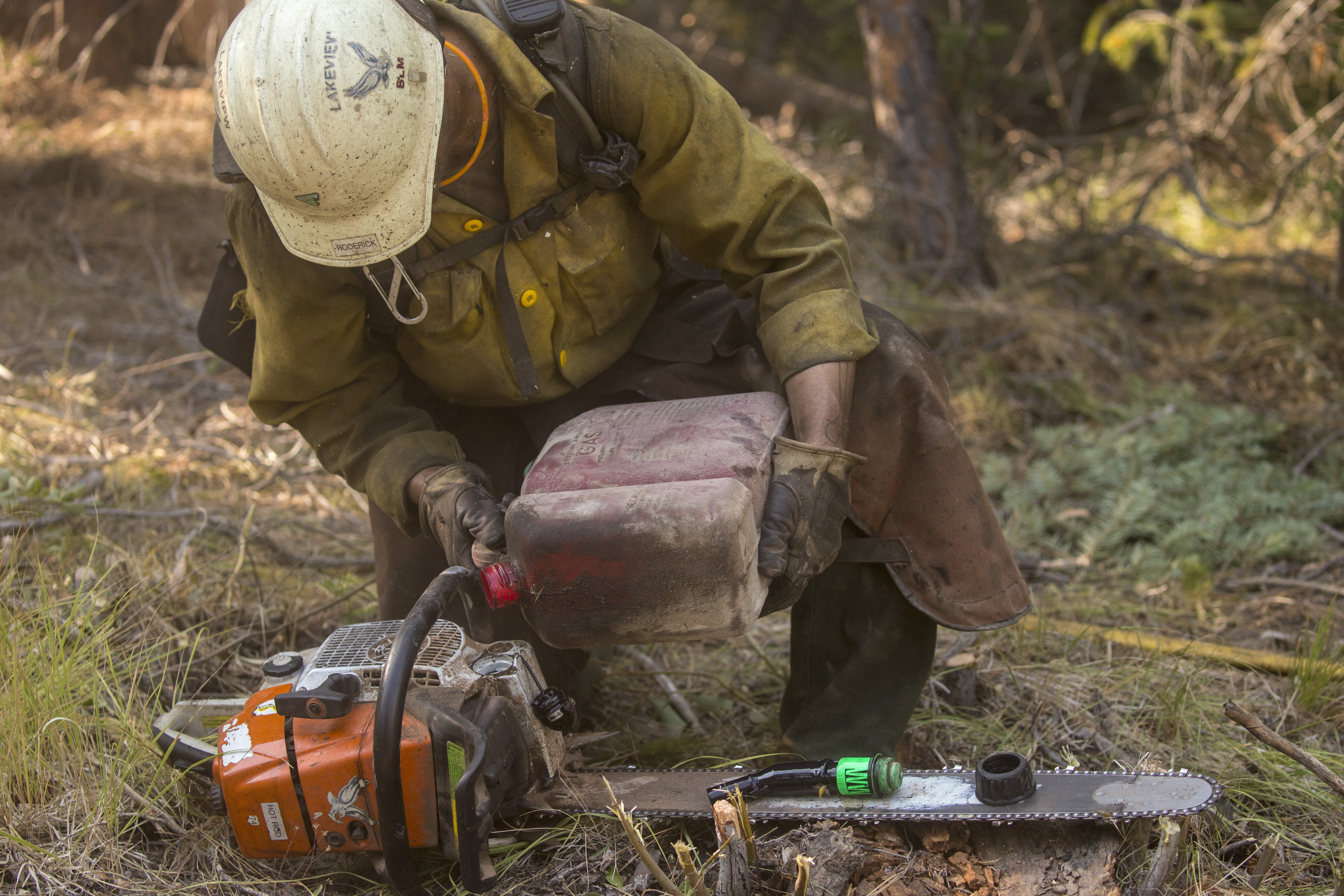 Firefighter maintains a chainsaw.