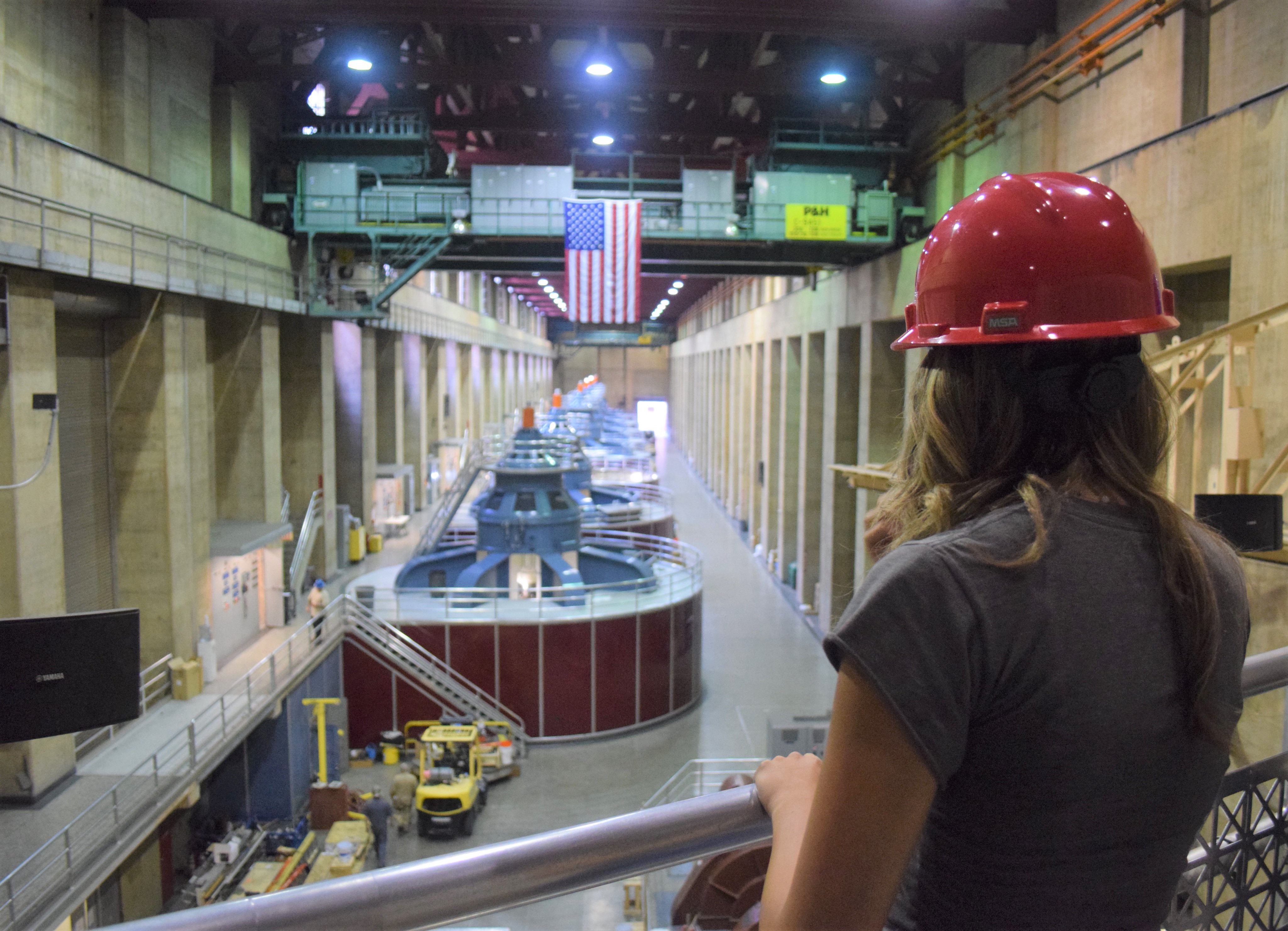 Hydrologist looking over railing at interior of Hoover Dam