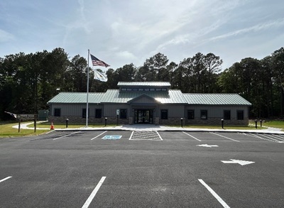 New building with a parking lot in front and an American flag blowing in the wind.
