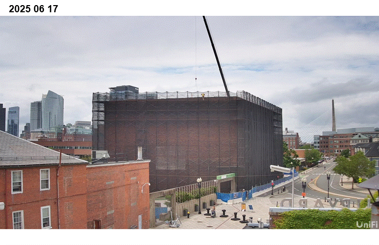 Timelapse showing the demolition of a building being demolished with a city scape in the background