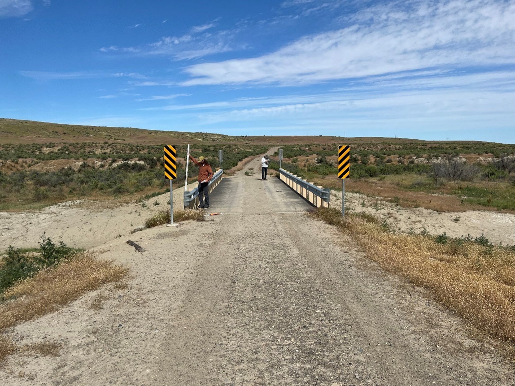 Completed repairs to the Neiber Bridge with hazard markers in a dry landscape.