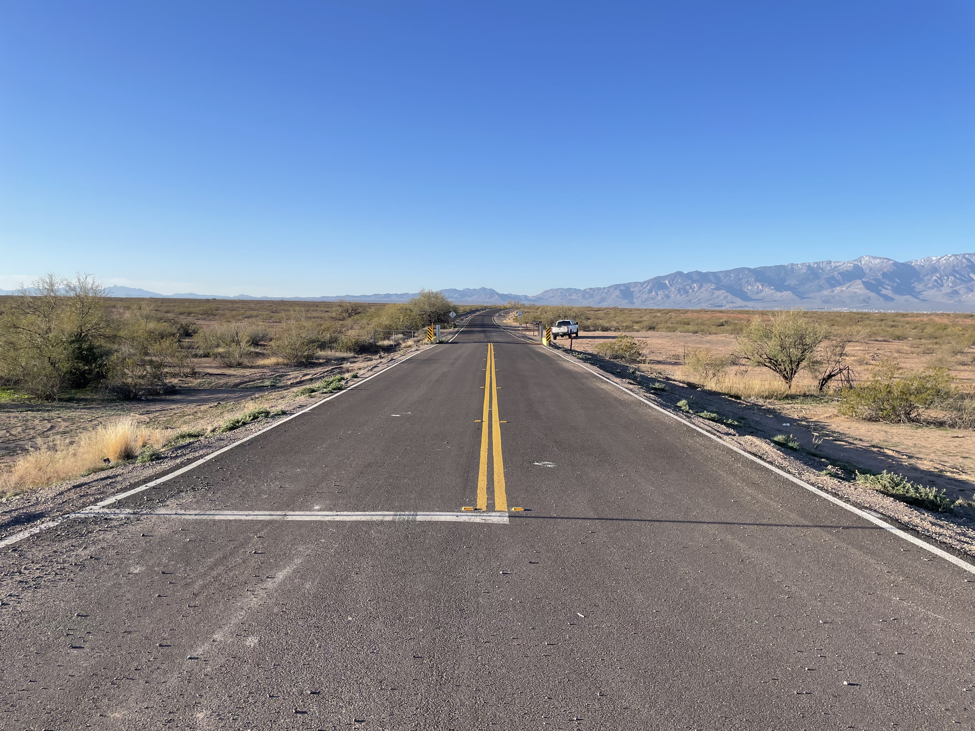 Newly paved road with yellow double lines in a dry landscape