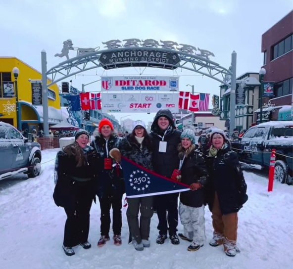 Snowy race start with group holding 250 flag