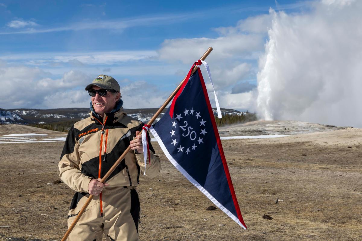 Secretary Burgum holding commemorative 250 flag
