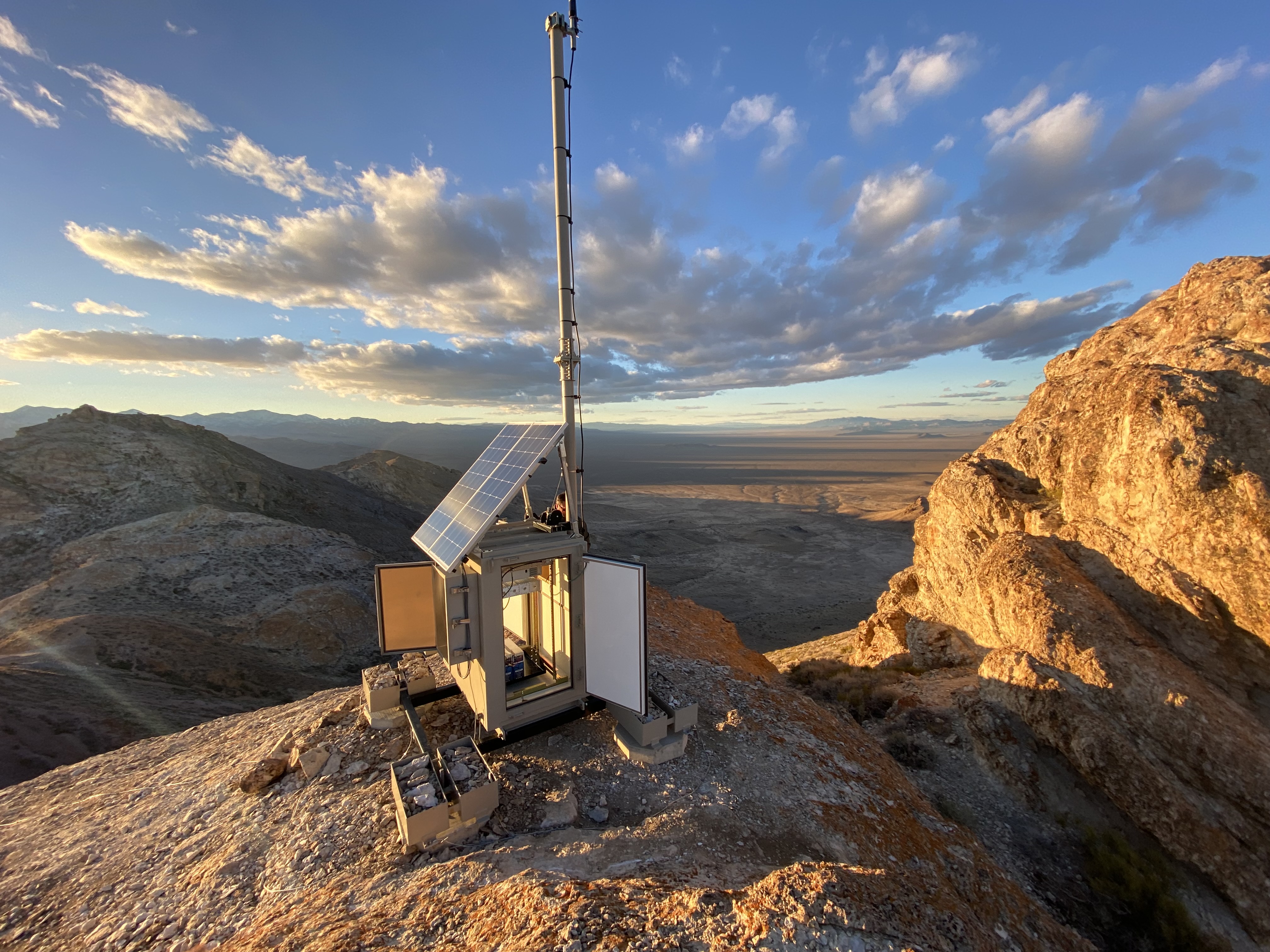 Newly restored solar-powered telecommunications tower on a rocky landscape.