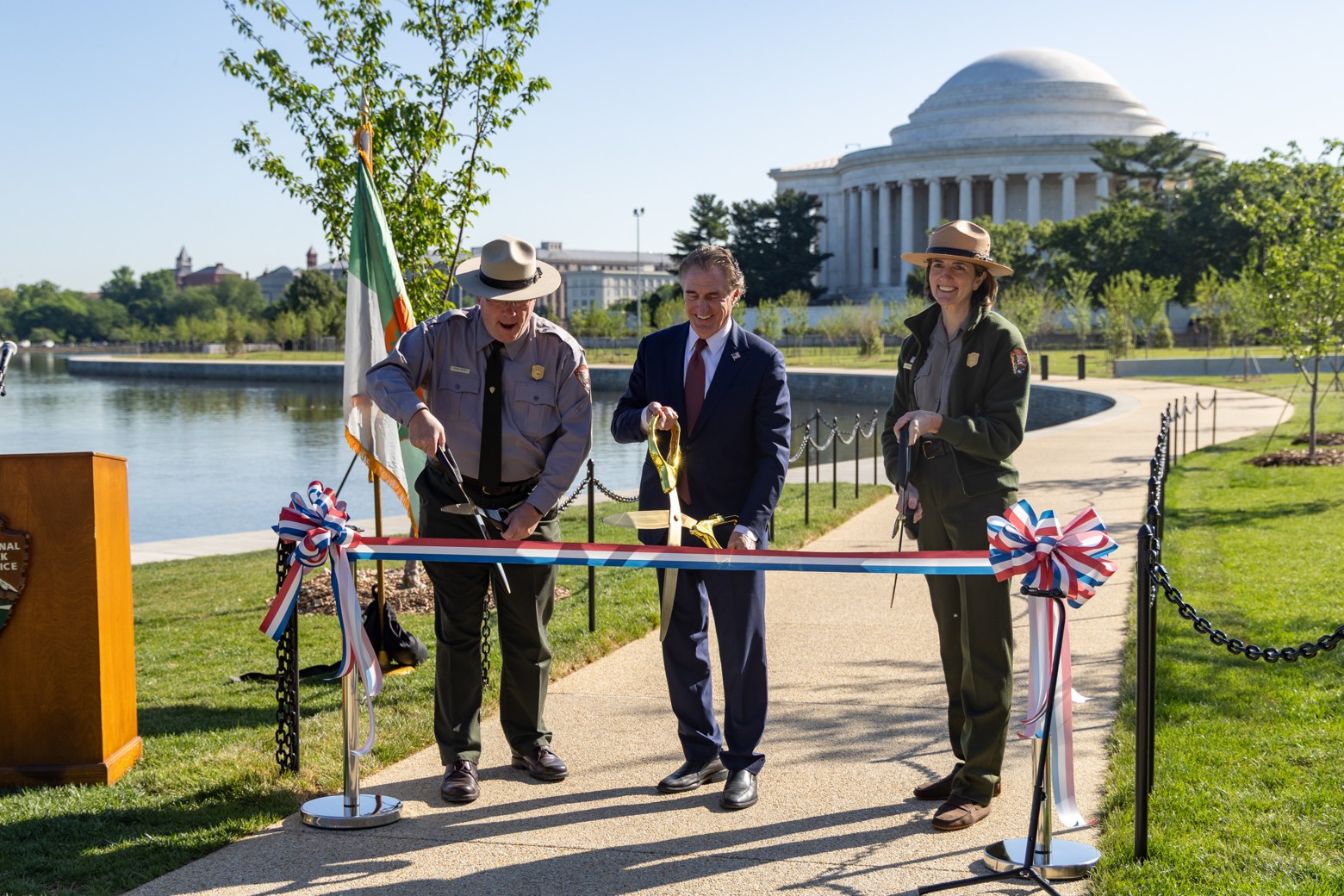 Great American Outdoors Act Anniversary - Ribbon Cutting Ceremony Secretary Burgum and two park rangers cutting red white and blue ribbon at ribbon cutting ceremony.