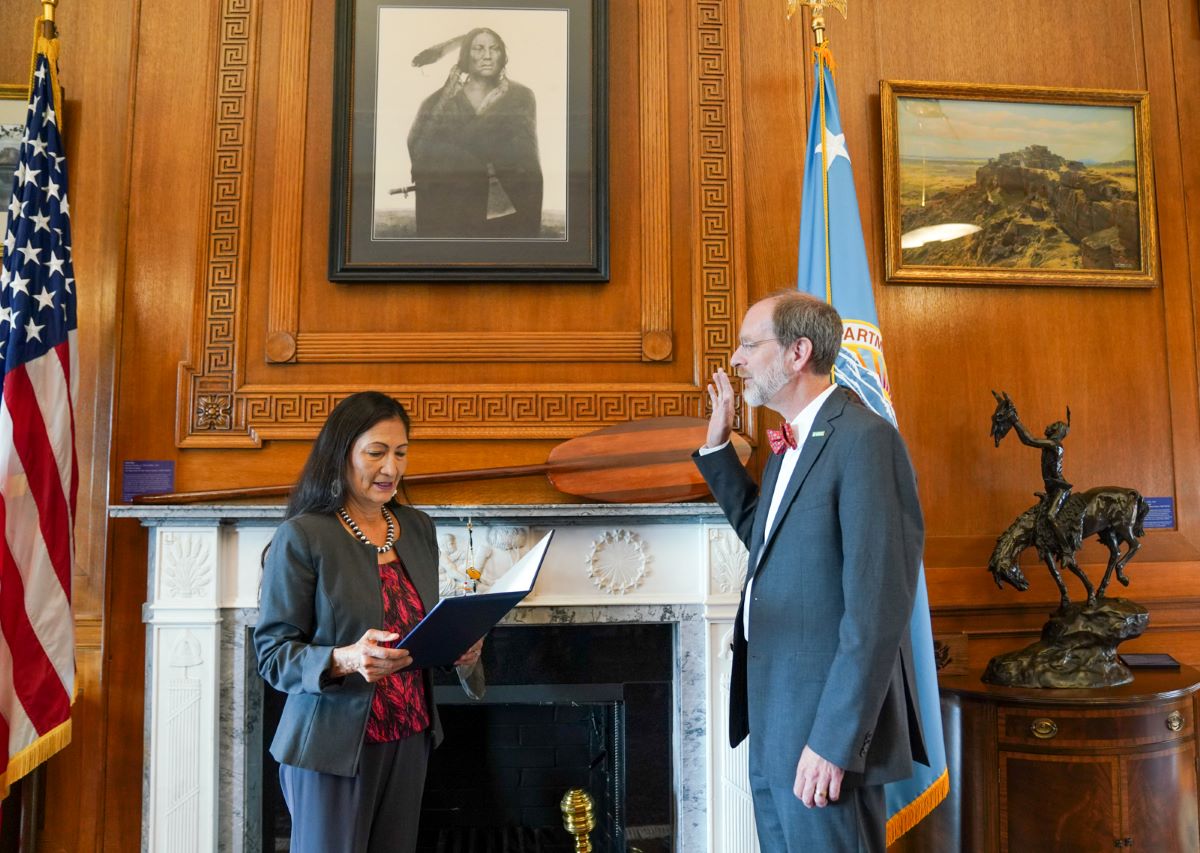 David Applegate raises his right hand as he is sworn in by Secretary of the Interior Deb Haaland