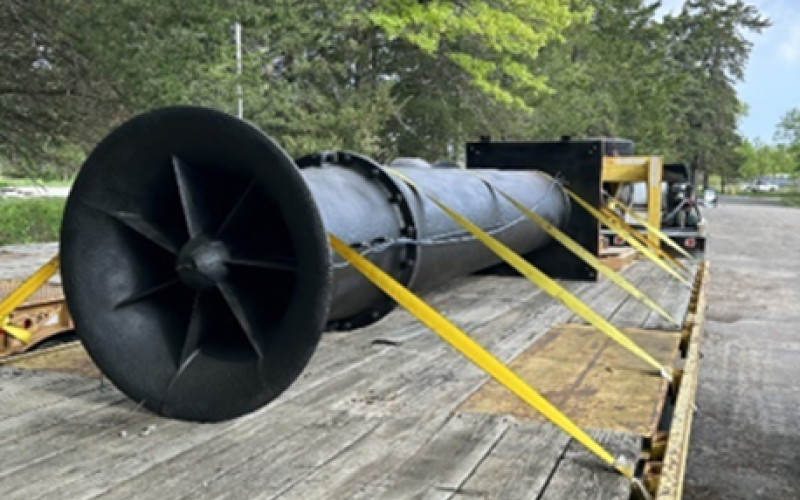 Pumping equipment piece secured to a long truck bed in transport. 