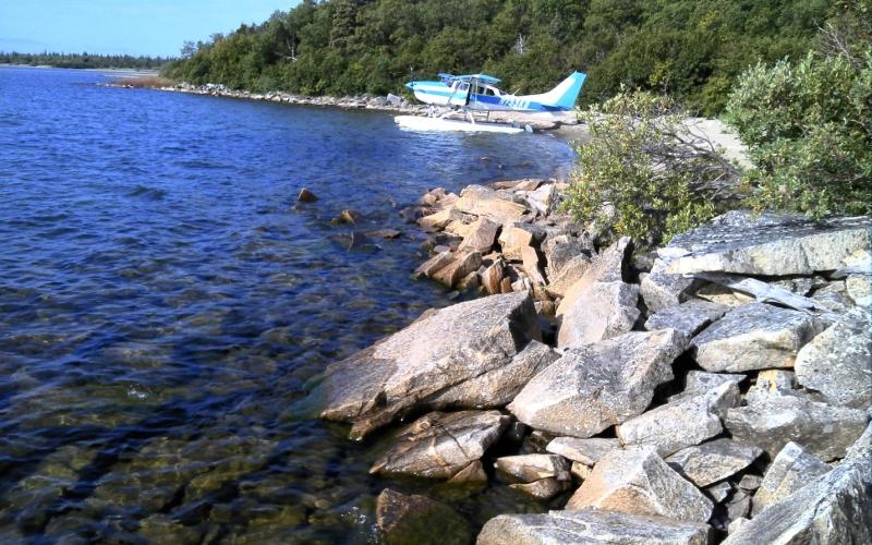 A float plane rests on the lake near shore