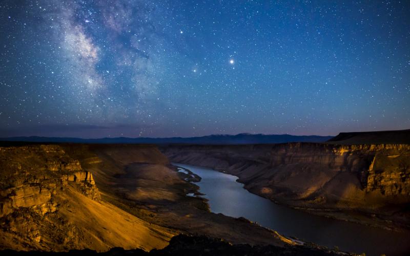 The deep canyon of the Snake River under a starry sky.