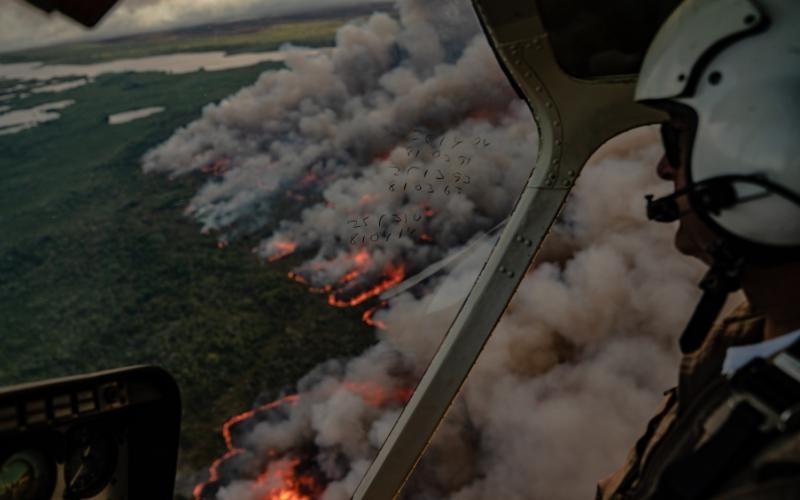 Helicopter pilot overlooks wildfire.