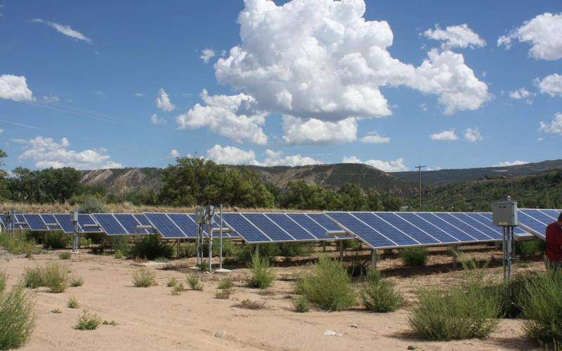 Solar panels under a partially-clouded sky in Colorado.