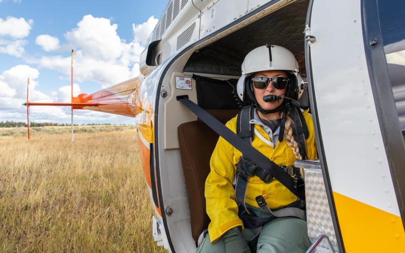 Helitack crew member ready for flight with a plastic sphere dispenser.