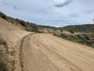 Newly repaired dirt road winds through hilly landscape.