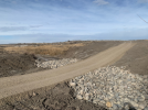 Dirt road surrounded by rocks at its lowest point.