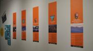 Section of the exhibition entitled, "On Location" consisting of five vertical panels and a magnetic tile-matching game.