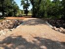Gravel crossing over creek surrounded by rocks on both sides.