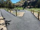 A paved path with handrails leading to a picnic table.