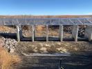 Metal water control structure with grassy field in the background