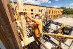 Construction worker repairs wooden building structure