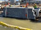 Brick seawall structure being repaired by team of construction workers