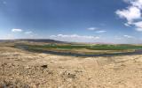 Sprawling ranchland with a river snaking through it