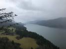 Overcast day, a wide, dark river in a tree-lined gorge