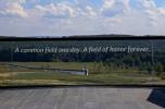 A glass monument reads, "A common field one day. A field of honor forever." 