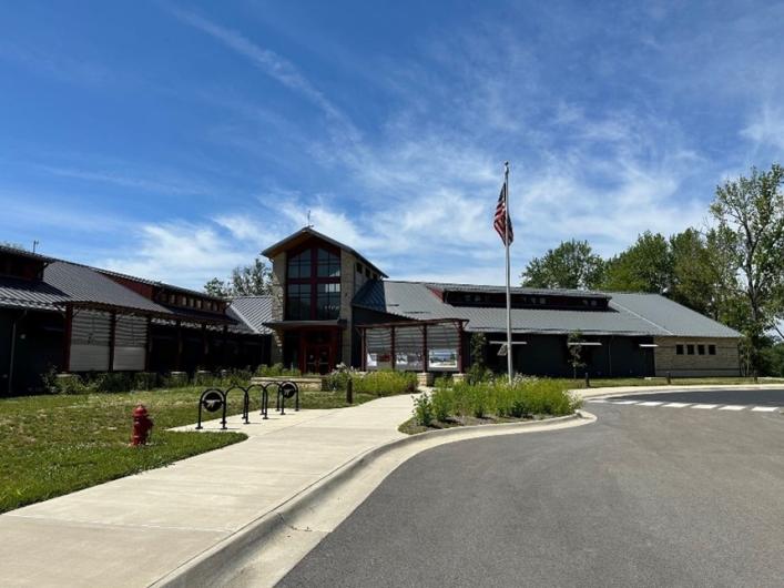 The completed new visitor center with a sloped roof under a blue sky.