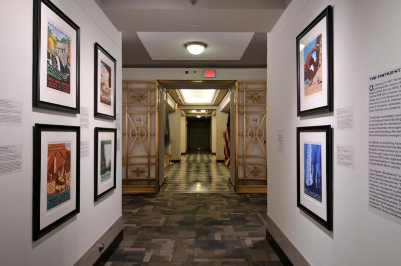 View of the "POSTERity" exhibition with interpretive panels and six framed serigraphs visible.
