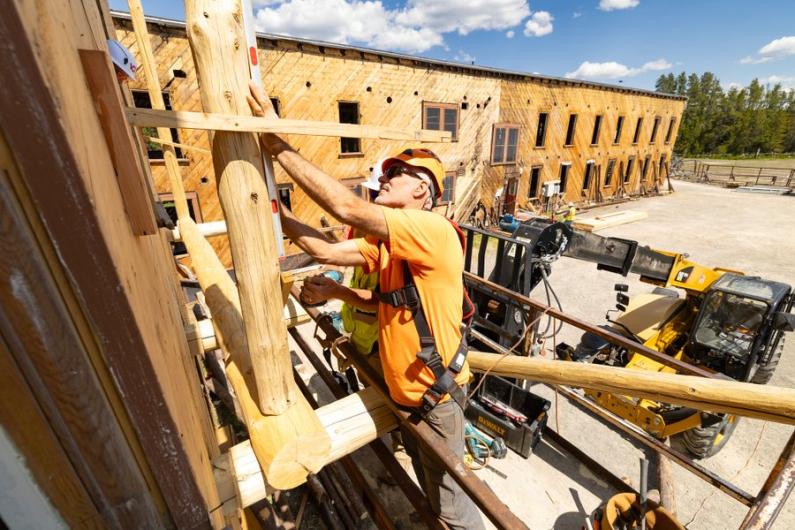 Construction worker repairs wooden building structure