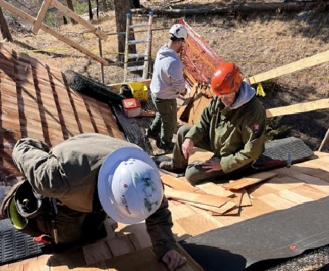 Maintenance Workers repair wooden roof