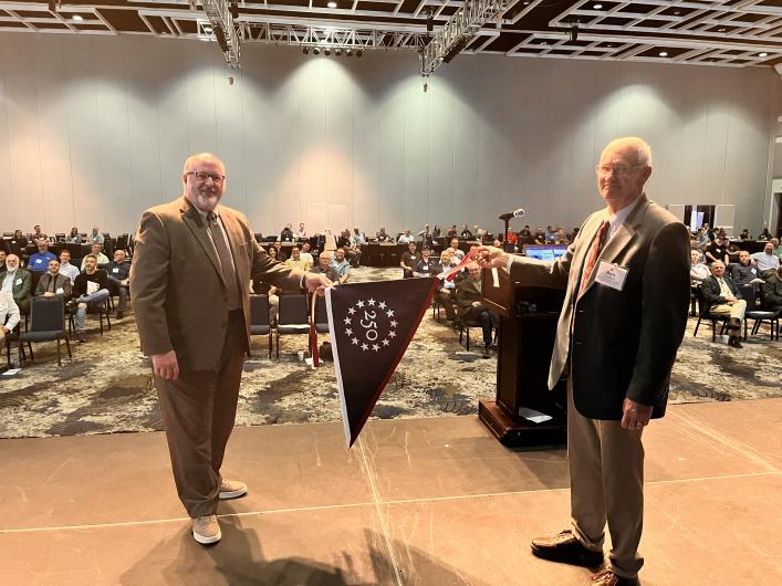 Two people holding flag in front of crowd