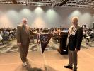 Two people holding flag in front of crowd