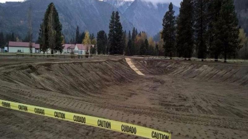Fishpond construction zone near mountains. 