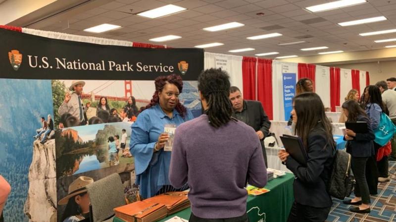 A National Park Service employee speaks to job seekers