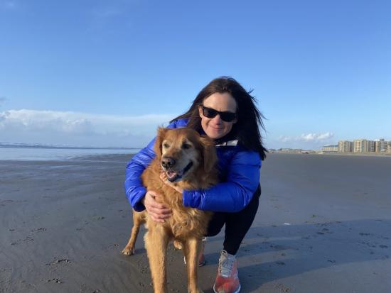 Erin hugs her dog on a beach