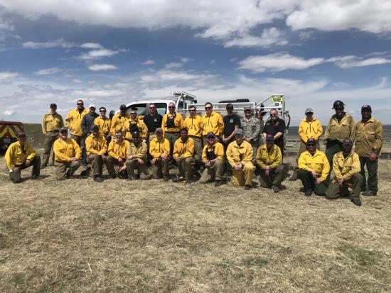 A group of firefighters standing in front of a fire truck