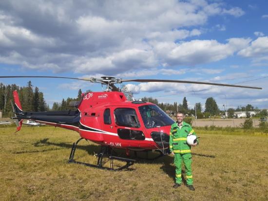 Peter Brick stands next to a helicopter before taking a helicopter flight. 
