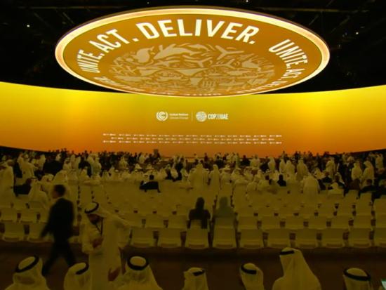 An illuminate COP28 sign hangs above the conference hall in Dubai.