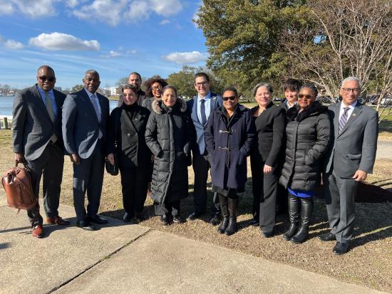 Secretary Haaland and 11 others smile for photo