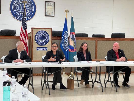 Secretary Haaland and 3 others sit at table in a discussion