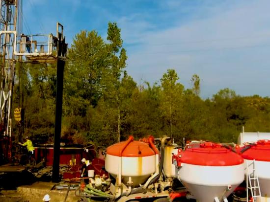 Workers in yellow safety gear and helmets at the site of an abandoned well in Michigan