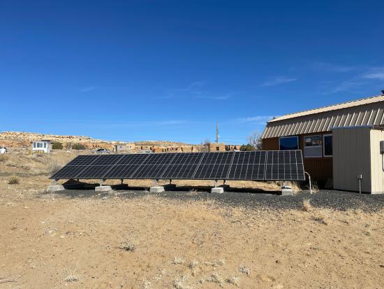 Solor panels along building in desert landscape
